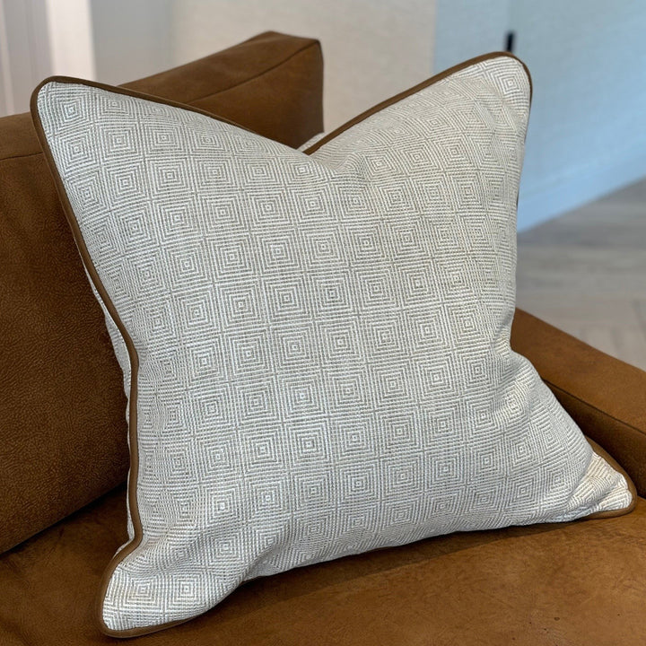 Luxury cushion in an ecru and natural geometric pattern, with a tan coloured piping. A plump feather inner cushion is included. Our made to order cushions are plump and cosy. Dimensions: 600 x 600 mm Made to order in approx 3 weeks