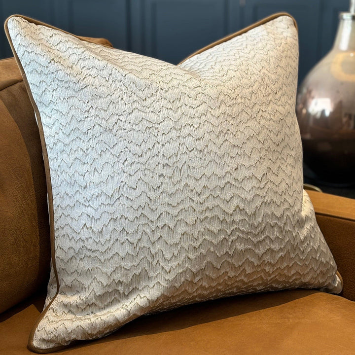 Luxury cushion in a satin finish ecru and tan pattern, with tan coloured piping. A plump feather inner cushion is included. Our made to order cushions are plump and cosy.  Dimensions: 600 x 600 mm  Made to order in approx 3 weeks