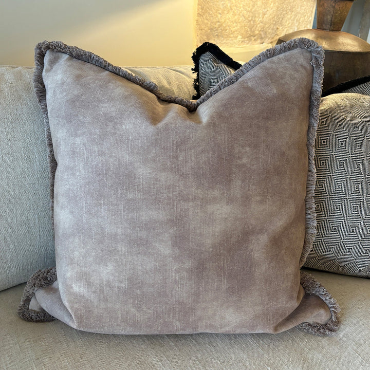 Luxury velvet and fringed cushion in mocha taupe. The fabric has a textured effect look but is a beautiful smooth finished fabric. Pictured with our taupe colourfed fringe, also available in our carefully selected piping colours, and alternative fringe colours. A plump feather inner cushion is included. Our luxury made to order cushions are plump and cosy.  Available sizes in cm: Square: 45 x 45 / 50 x 50 / 60 x 60  Rectangular: 30 x 48 / 30 x 56 / 35 x 56  Made to order in approx 3 weeks